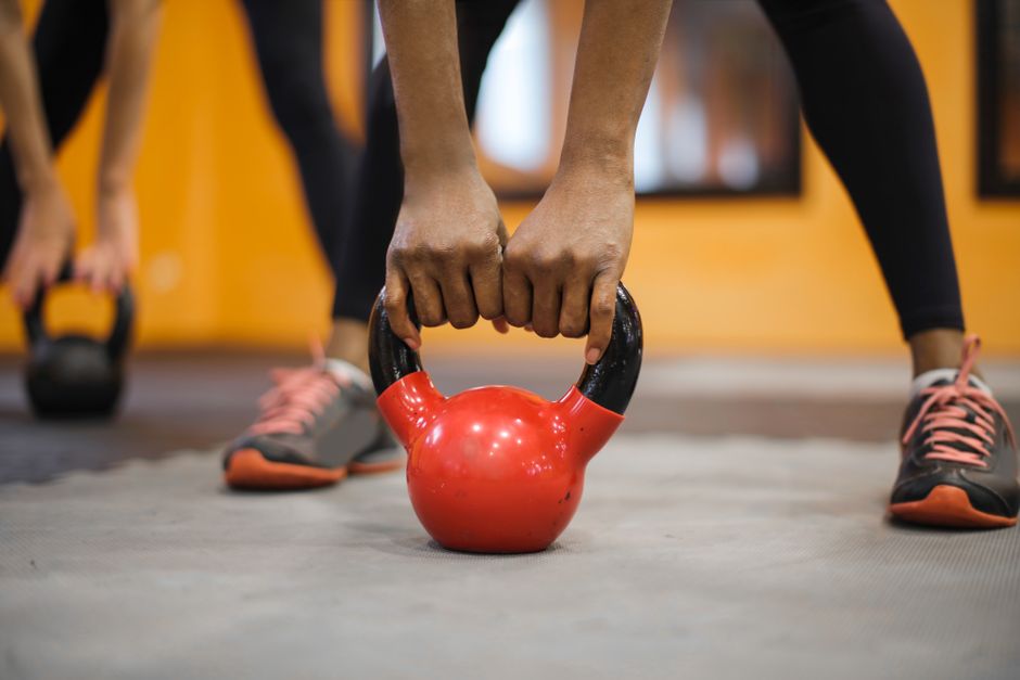 Ruke na crvenom kettlebellu