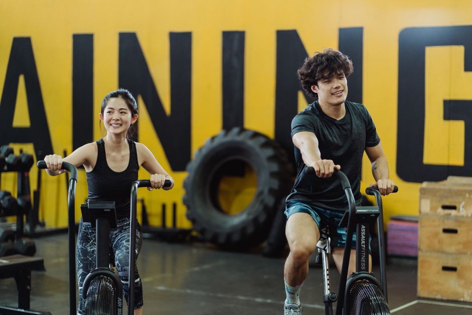 Happy couple enjoying an indoor cycling workout together, enhancing fitness i having fun.